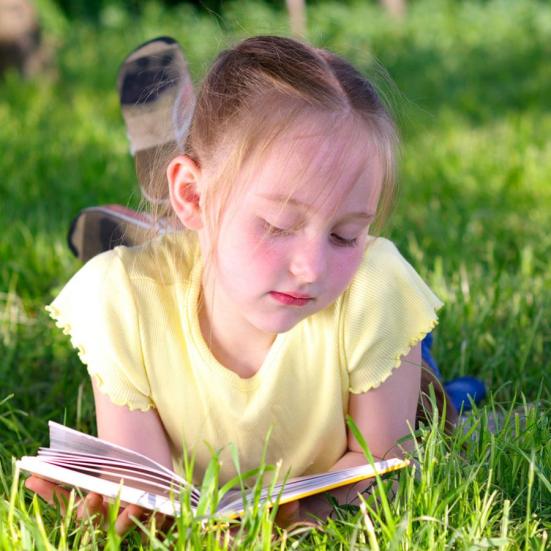 Pige der læser bøger fra biblioteket