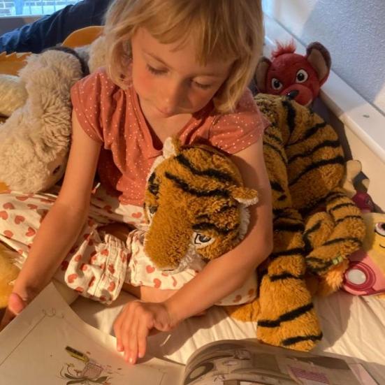 Alvilda på 5 år læser op for  bamsen "Tiger"