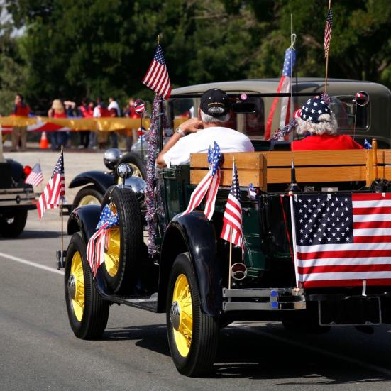 Et biloptog med amerikanske flag til fejringen af 4. juli