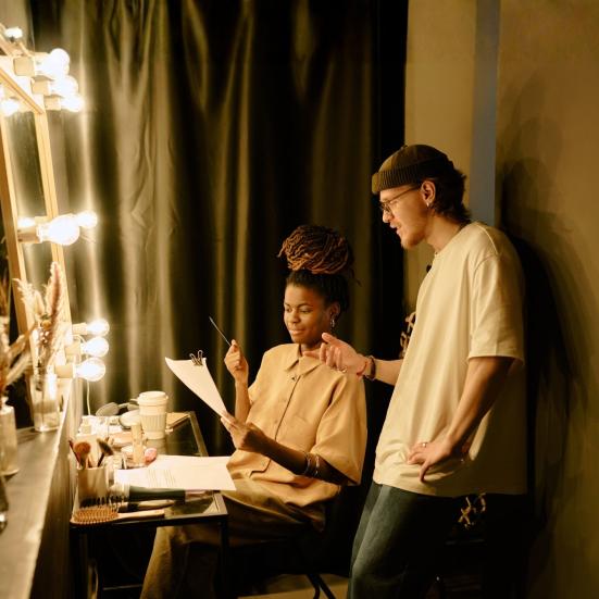 To personer i teatergarderobe kigger i manus