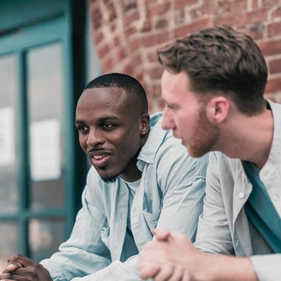 Foto af to mænd, der taler sammen udenfor