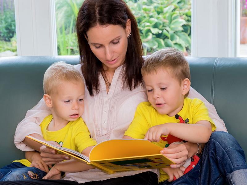 Små børn der læser sammen med en voksen