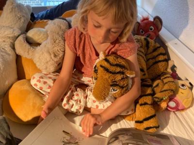 Alvilda på 5 år læser op for  bamsen "Tiger"