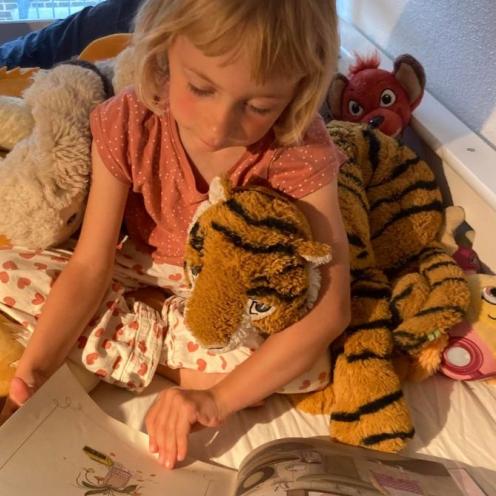 Alvilda på 5 år læser op for  bamsen "Tiger"